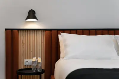 a bed with a white pillow and a side table at Acropolis White Key Residence in Athens