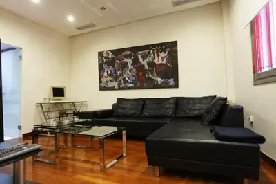 a living room with a black couch and a table at Olvias Apartment in Athens