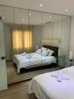 a bedroom with two beds and a mirror at Olvias Apartment in Athens