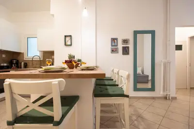 a kitchen with a counter with chairs and a table at Blue Ark Comfort near Acropolis in Athens