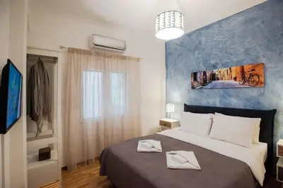 a bedroom with a large bed with a blue wall at Blue Ark Comfort near Acropolis in Athens
