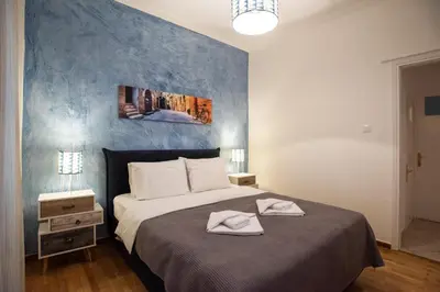 a bedroom with a bed with a blue accent wall at Blue Ark Comfort near Acropolis in Athens