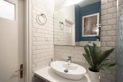 a white bathroom with a sink and a mirror at Blue Ark Comfort near Acropolis in Athens