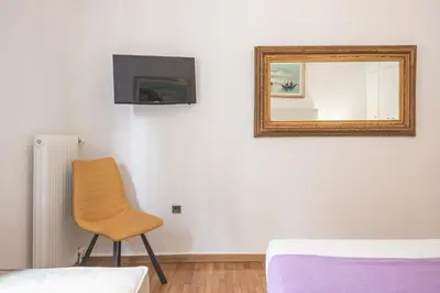 a mirror and a chair in a room at Victoria Majestic Suites Apartments in Athens