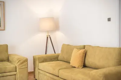 a living room with a couch and a lamp at Victoria Majestic Suites Apartments in Athens