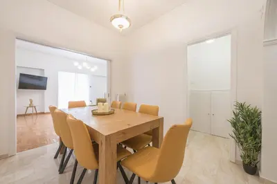 a dining room with a wooden table and chairs at Victoria Majestic Suites Apartments in Athens