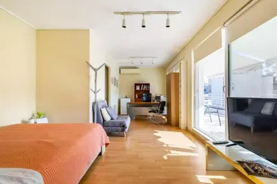a bedroom with a bed and a tv and a living room at Agia Paraskevi luxury loft in Athens