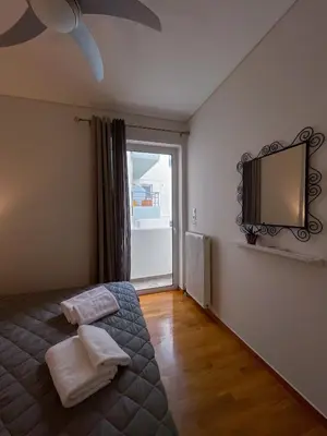 a bedroom with a bed and a television on the wall at Ageliki's Athens Apartment in Athens