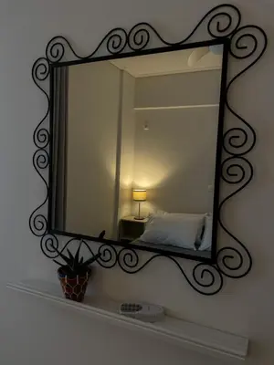 a mirror on a wall with a bed in it at Ageliki's Athens Apartment in Athens