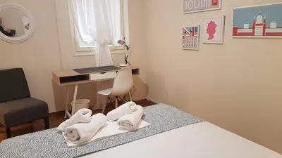 a room with a bed and a desk with towels at Begonia-Athens Center, 6 BD, 2,5 BATH in Athens