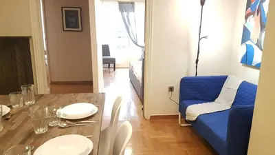 a living room with a table and a blue couch at Begonia-Athens Center, 6 BD, 2,5 BATH in Athens