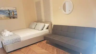 a small living room with a couch and a mirror at Coral Athens Centrer - 3,5 BD , 2 BATH in Athens