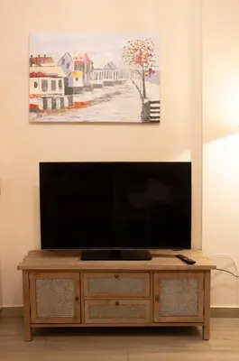 a flat screen tv sitting on top of a wooden cabinet at Αcacia House - Fully Equipped Apartment in Glyfada in Athens