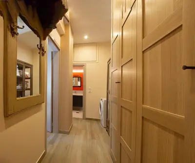 a hallway with a wooden door and a kitchen at Αcacia House - Fully Equipped Apartment in Glyfada in Athens