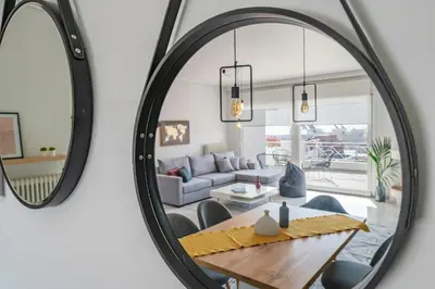 a mirror in a living room with a table and a couch at Bright 3bdr Apt with Roofgarden, Jacuzzi in Athens