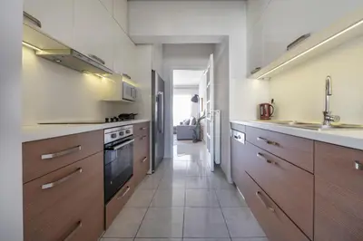 a large kitchen with wooden cabinets and a sink at Bright 3bdr Apt with Roofgarden, Jacuzzi in Athens