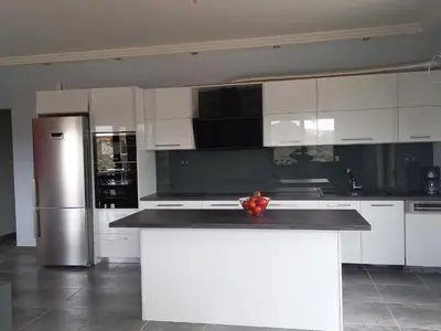 a kitchen with white cabinets and a black counter top at summer-house in Metókhi