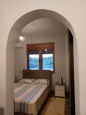 a bedroom with a large bed with an archway at summer-house in Metókhi