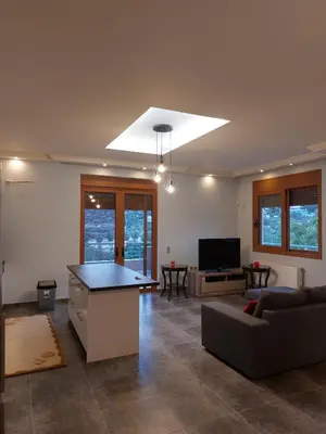 a living room with a couch and a table at summer-house in Metókhi