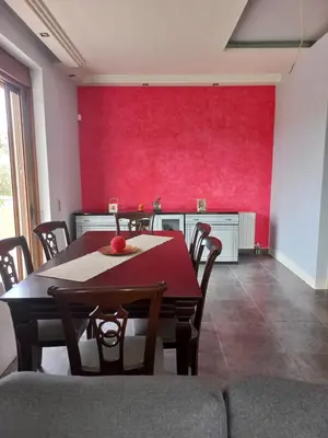 a dining room with a table and a red wall at summer-house in Metókhi