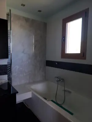 a bathroom with a bath tub and a window at summer-house in Metókhi