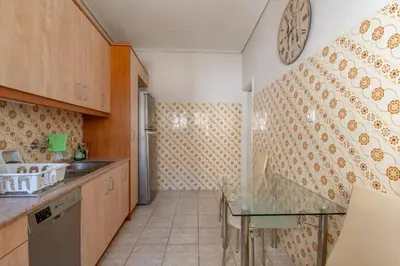a kitchen with a table and a clock on the wall at Marina Zeas Classyhub in Piraeus