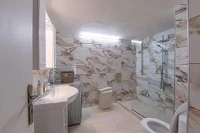a white bathroom with a sink and a shower at Marina Zeas Classyhub in Piraeus