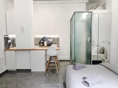 a room with two beds and a counter with a chair at KYMA Apartments - Athens Acropolis 22 in Athens