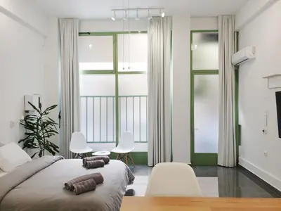 a bedroom with a large bed and a table and chairs at KYMA Apartments - Athens Acropolis 22 in Athens