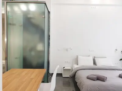 a bedroom with two beds and a glass wall at KYMA Apartments - Athens Acropolis 22 in Athens