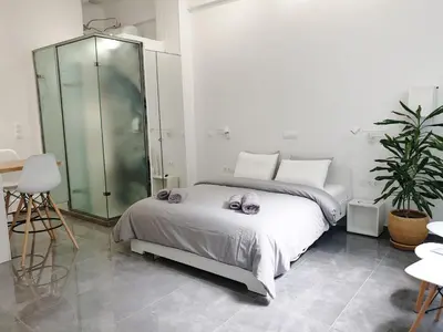 a bedroom with a bed and a glass shower at KYMA Apartments - Athens Acropolis 22 in Athens