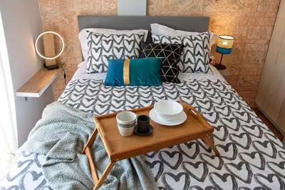 a bed with a table with two cups on it at Athenian Sun-Kissed Penthouse with huge Balcony! in Athens
