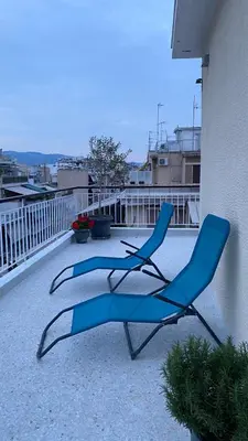 two blue chairs sitting on top of a balcony at Athenian Sun-Kissed Penthouse with huge Balcony! in Athens