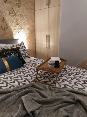 a bedroom with a bed with a table on it at Athenian Sun-Kissed Penthouse with huge Balcony! in Athens