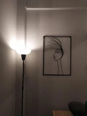 a lamp next to a wall with a drawing on it at Athenian Sun-Kissed Penthouse with huge Balcony! in Athens