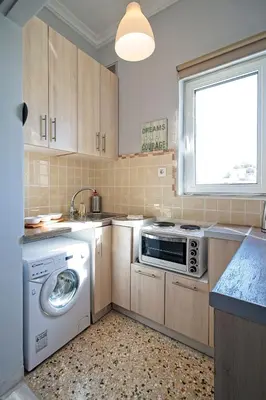 a kitchen with a washing machine and a window at Athenian Sun-Kissed Penthouse with huge Balcony! in Athens