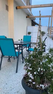 a patio with blue chairs and a table and a plant at Athenian Sun-Kissed Penthouse with huge Balcony! in Athens