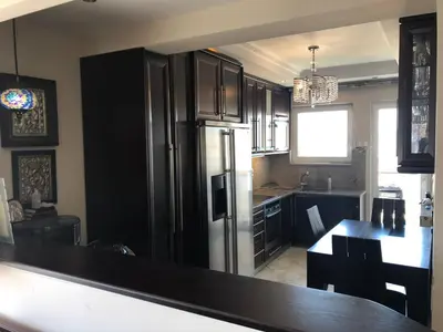 a kitchen with a refrigerator and a table in it at Glifada Calm Luxury Flat One in Athens