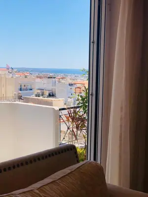 a window with a couch and a view of a city at Glifada Calm Luxury Flat One in Athens