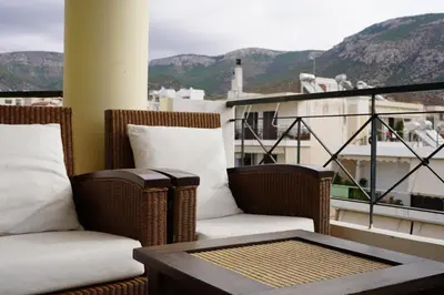a balcony with wicker chairs and a table on a balcony at Glifada Calm Luxury Flat One in Athens