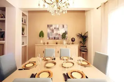 a dining room with a table with chairs and a chandelier at Νew Thission Luxury Apartment in Athens