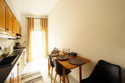 a small kitchen with a wooden table and chairs at Νew Thission Luxury Apartment in Athens
