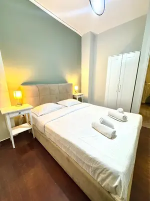 a bedroom with a large white bed with two towels on it at Athens City Themis 12 in Athens