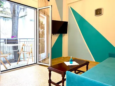 a living room with a couch and a table and a balcony at Kallithea's breeze in Athens