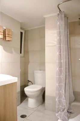 a bathroom with a toilet and a shower curtain at Kallithea's breeze in Athens