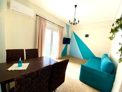 a dining room with a table and a blue chair at Kallithea's breeze in Athens
