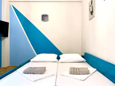 two beds in a room with blue and white at Kallithea's breeze in Athens