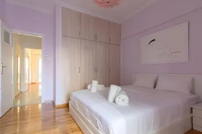 a bedroom with a white bed with towels on it at Bright and Spacious 2-bedroom Apartment in Athens in Athens