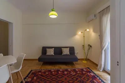 a living room with a couch and a rug at Bright and Spacious 2-bedroom Apartment in Athens in Athens