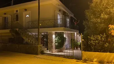 a house with a gate in front of it at night at Pallas in Keratea